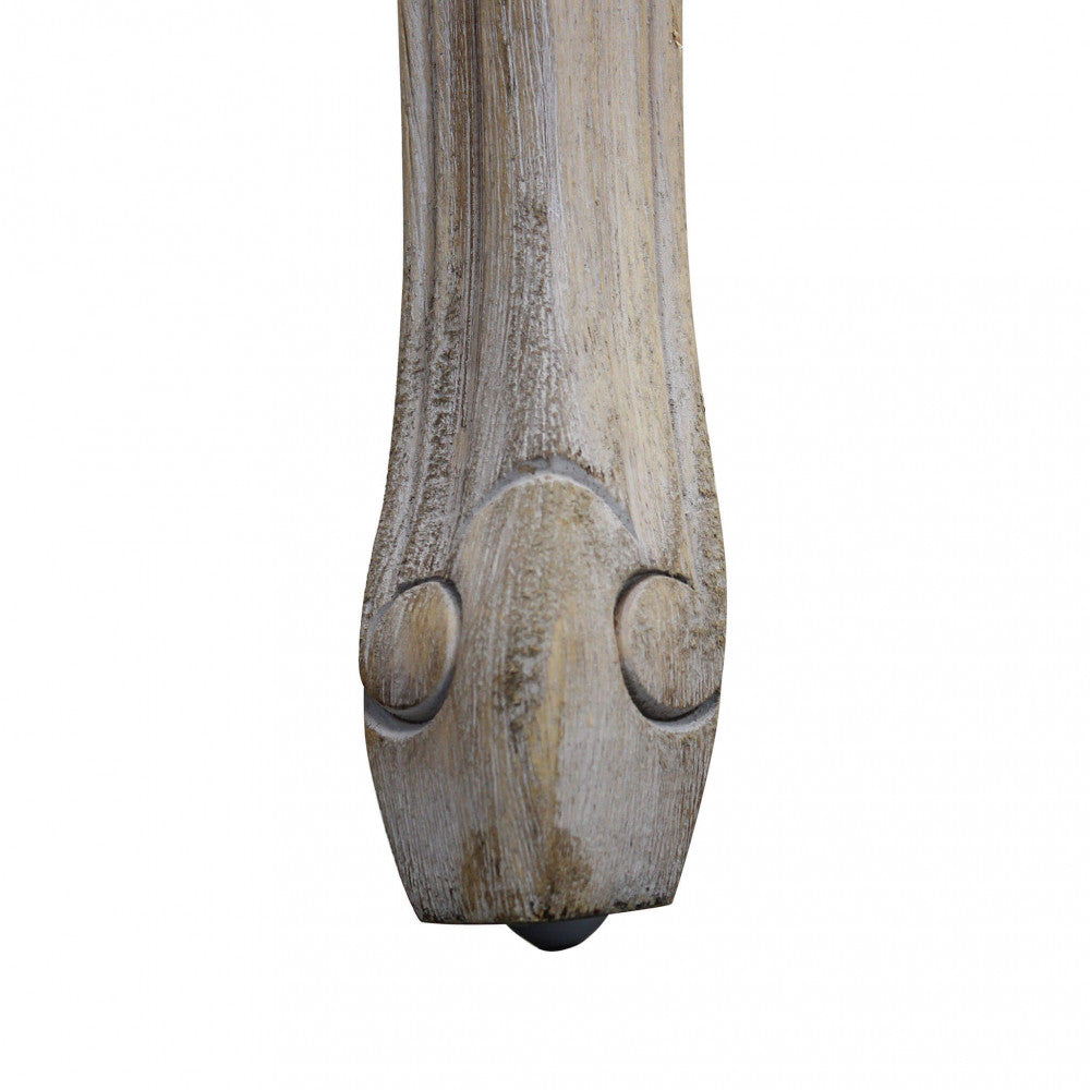 Dettaglio del piedino intagliato in legno massello con finitura anticata della panca Madelyn.