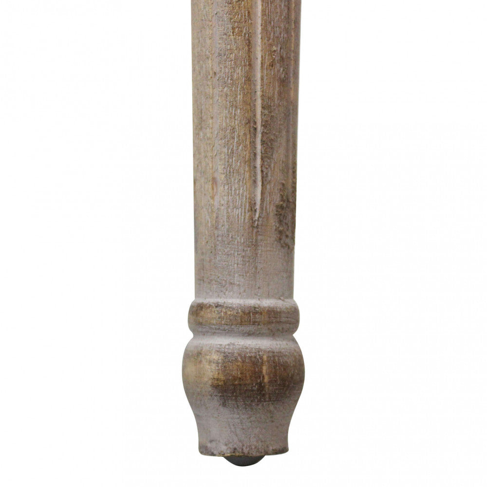 Dettaglio ravvicinato del piedino tornito in legno della panca Margi, con finitura anticata.