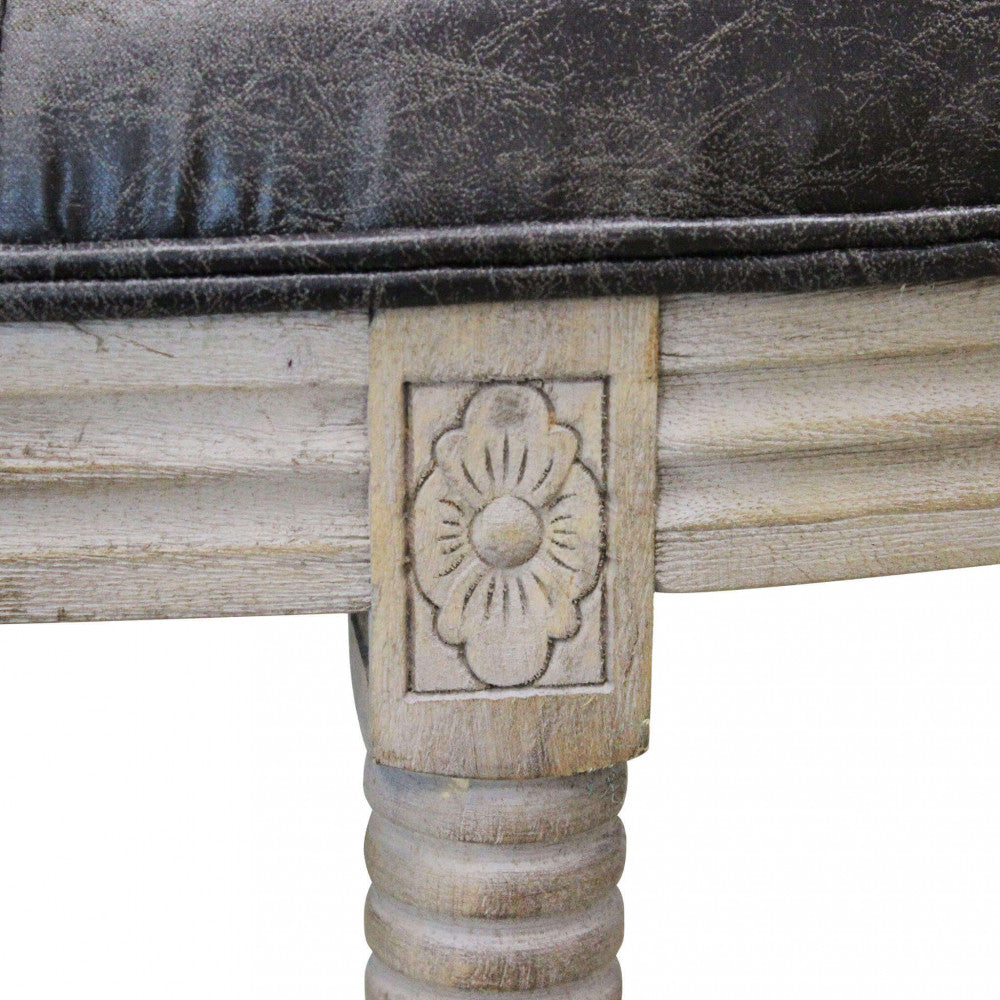 Dettaglio ravvicinato dell'intaglio floreale sul blocco superiore della gamba in legno della panca.