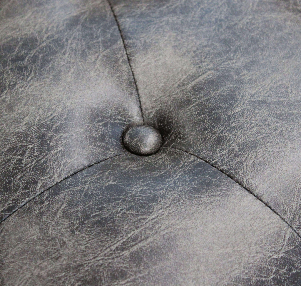 Dettaglio ravvicinato del bottone capitonné e della texture dell'ecopelle vintage grigio taupe.