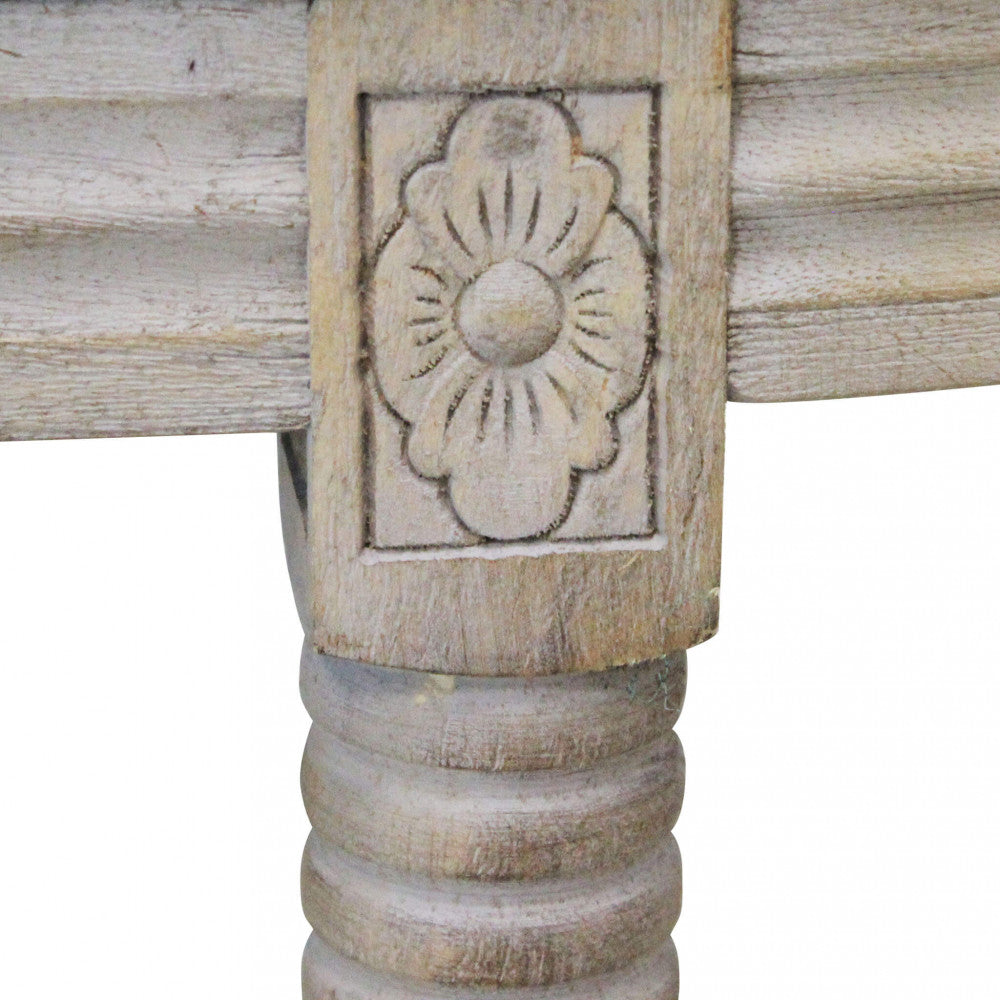 Particolare della gamba in legno tornito con decorazione floreale scolpita.