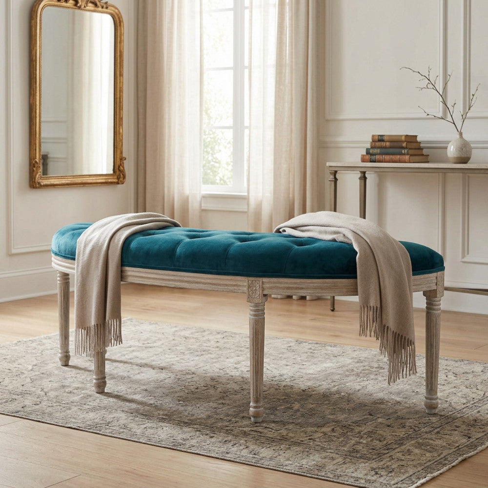 Panca Margi in velluto blu e legno posizionata in un ingresso elegante con specchio dorato.
