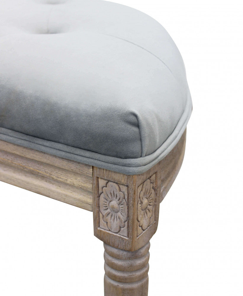 Dettaglio ravvicinato dell'intaglio floreale sul legno e della morbida imbottitura in velluto.