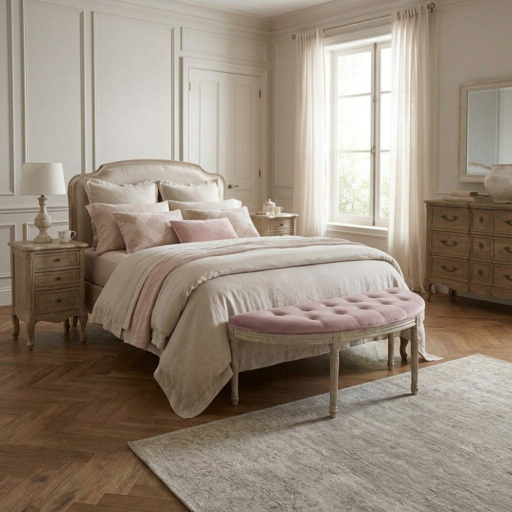 Panca Margi ai piedi di un letto matrimoniale in una camera da letto dai toni neutri e romantici.
