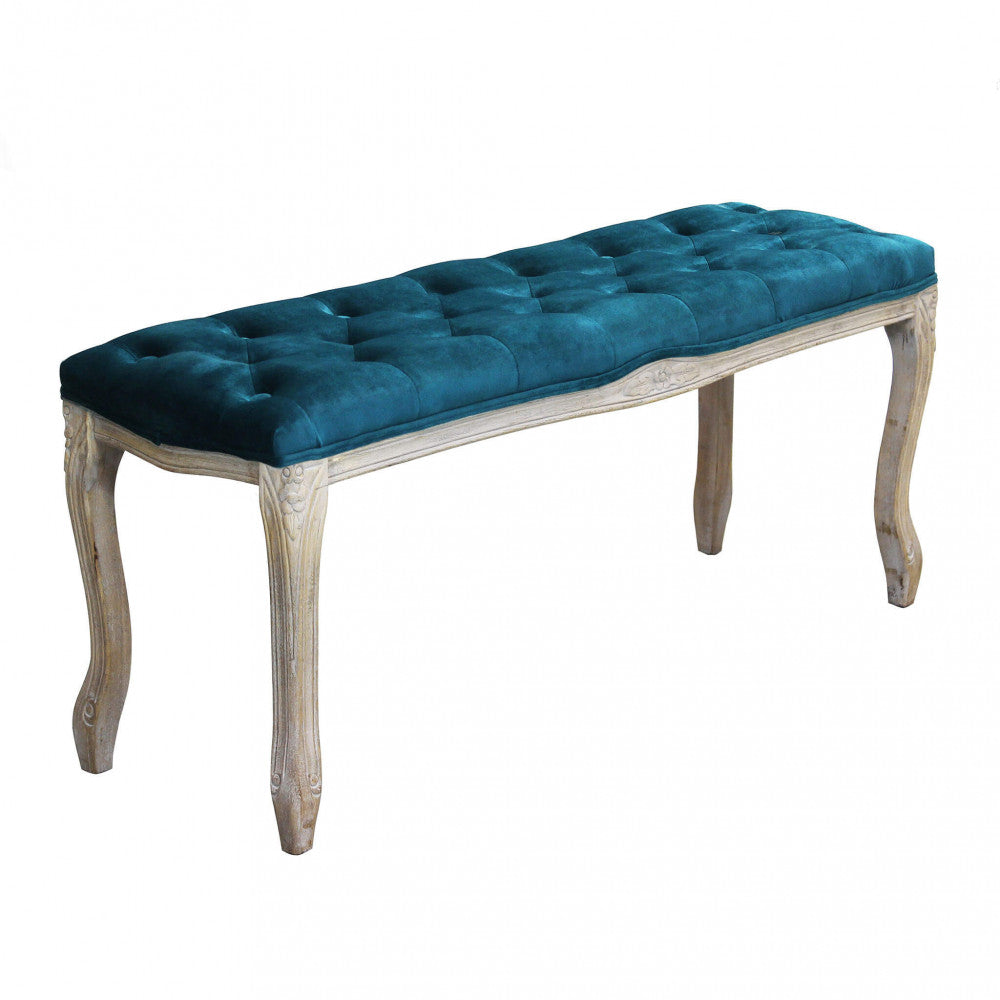Panca Misty isolata su sfondo bianco, che mostra la seduta capitonné in velluto blu e le gambe in legno curvato.