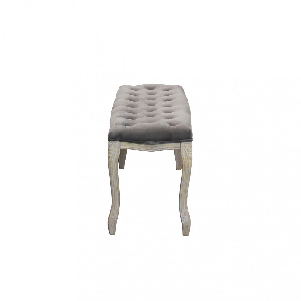 Profilo laterale della panca in velluto taupe, che mostra la curvatura elegante delle gambe in legno.