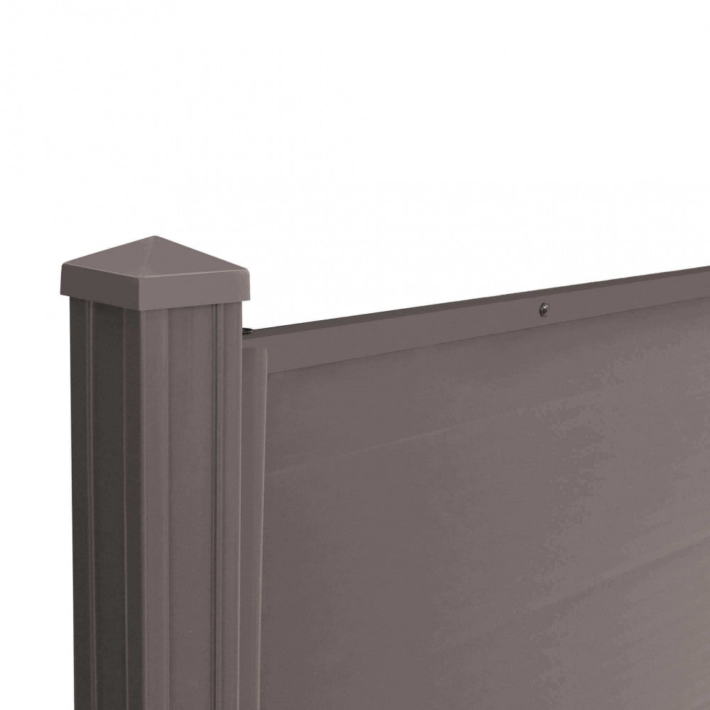 Pannello Fencing in plastica di colore marrone, utilizzato come delimitazione in un giardino verde, che mostra la sua texture e la semplicità di installazione | Albert Stock