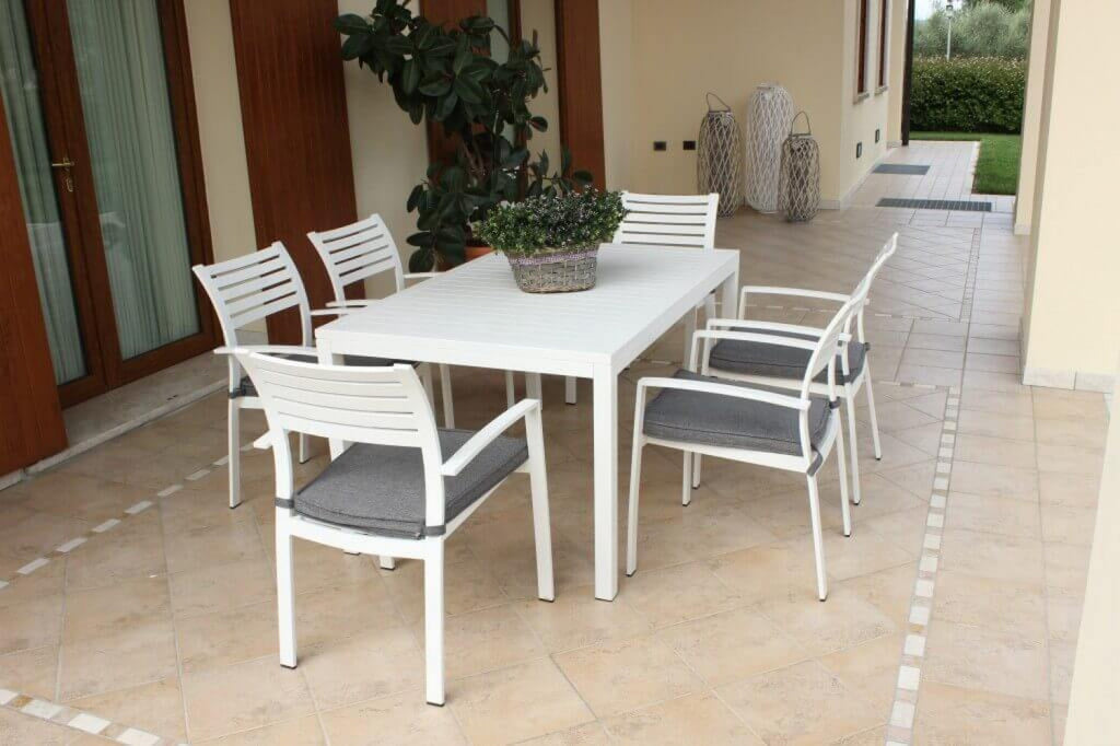 Panoramica-in-veranda-Tavolo Milo 150x90 cm in alluminio bianco, ambientato su una terrazza con sedie abbinate, che ne evidenzia il design pulito e la stabilità | Albert Stock