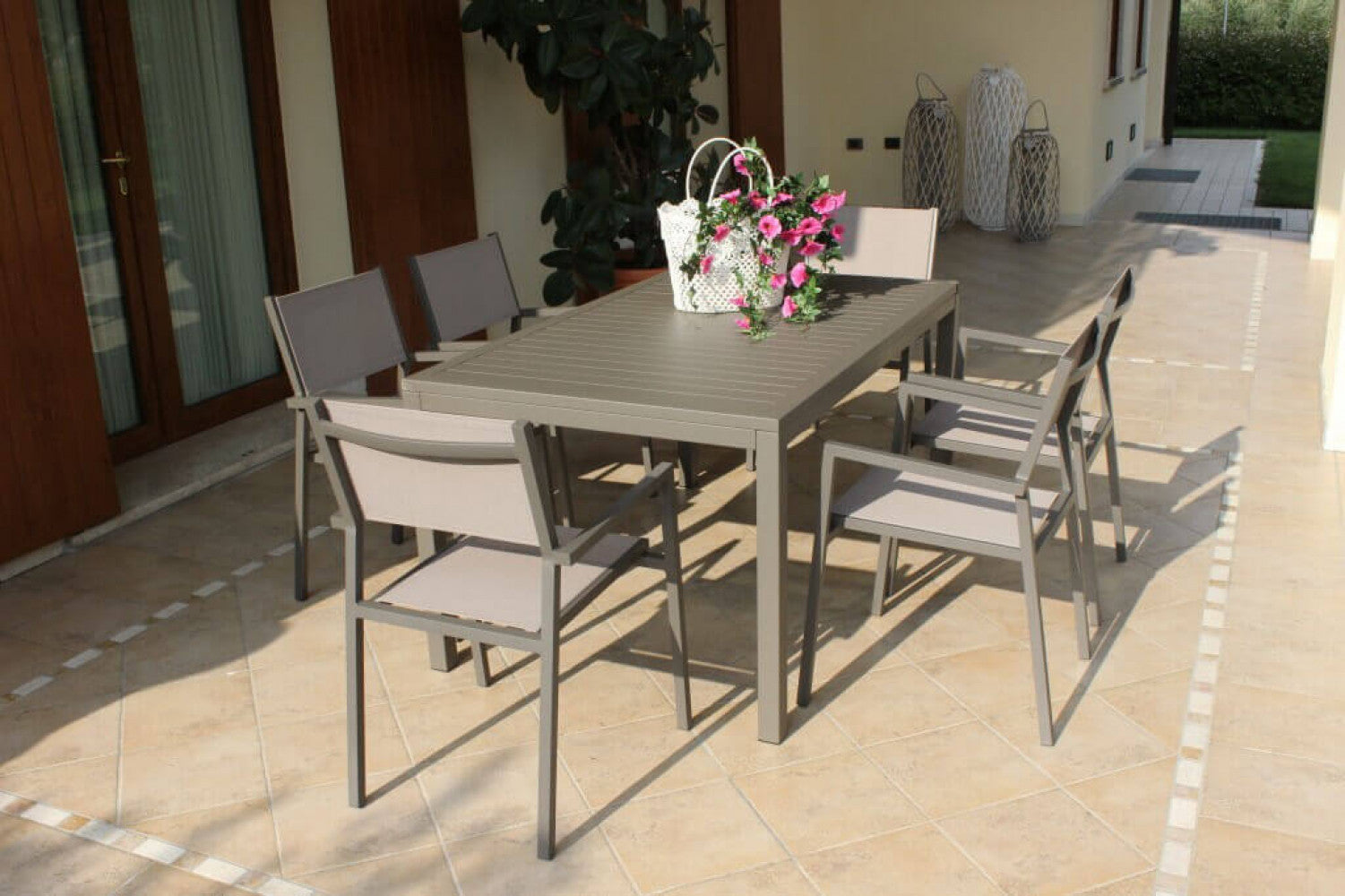 Panoramica in veranda con sedie del tavolo da giardino Milo 150x90 cm fisso, in alluminio verniciato taupe, ideale per aree pranzo esterne e per ambienti accoglienti | Albert Stock