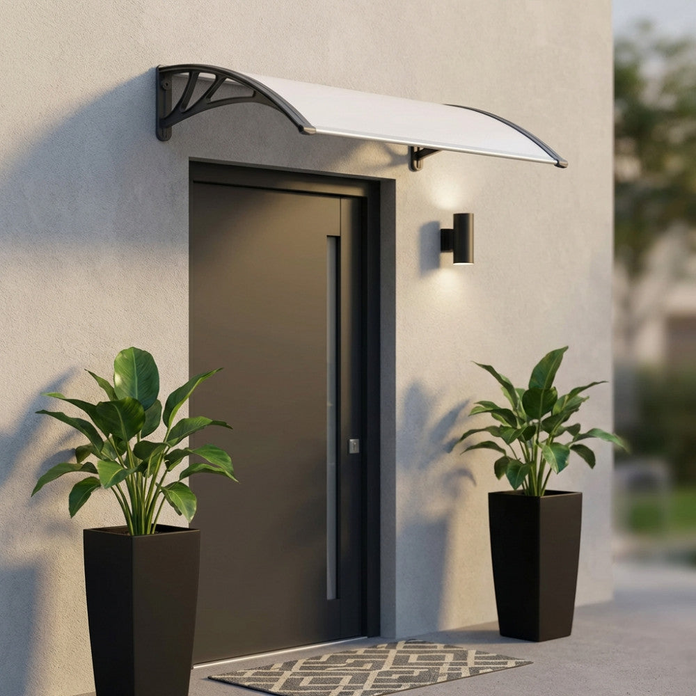 Pensilina in policarbonato trasparente grigio installata sopra una porta d'ingresso moderna grigio scuro.