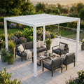 Pergola bioclimatica 3x3 in alluminio bianco che ombreggia un salotto da esterni grigio scuro su un patio lastricato.