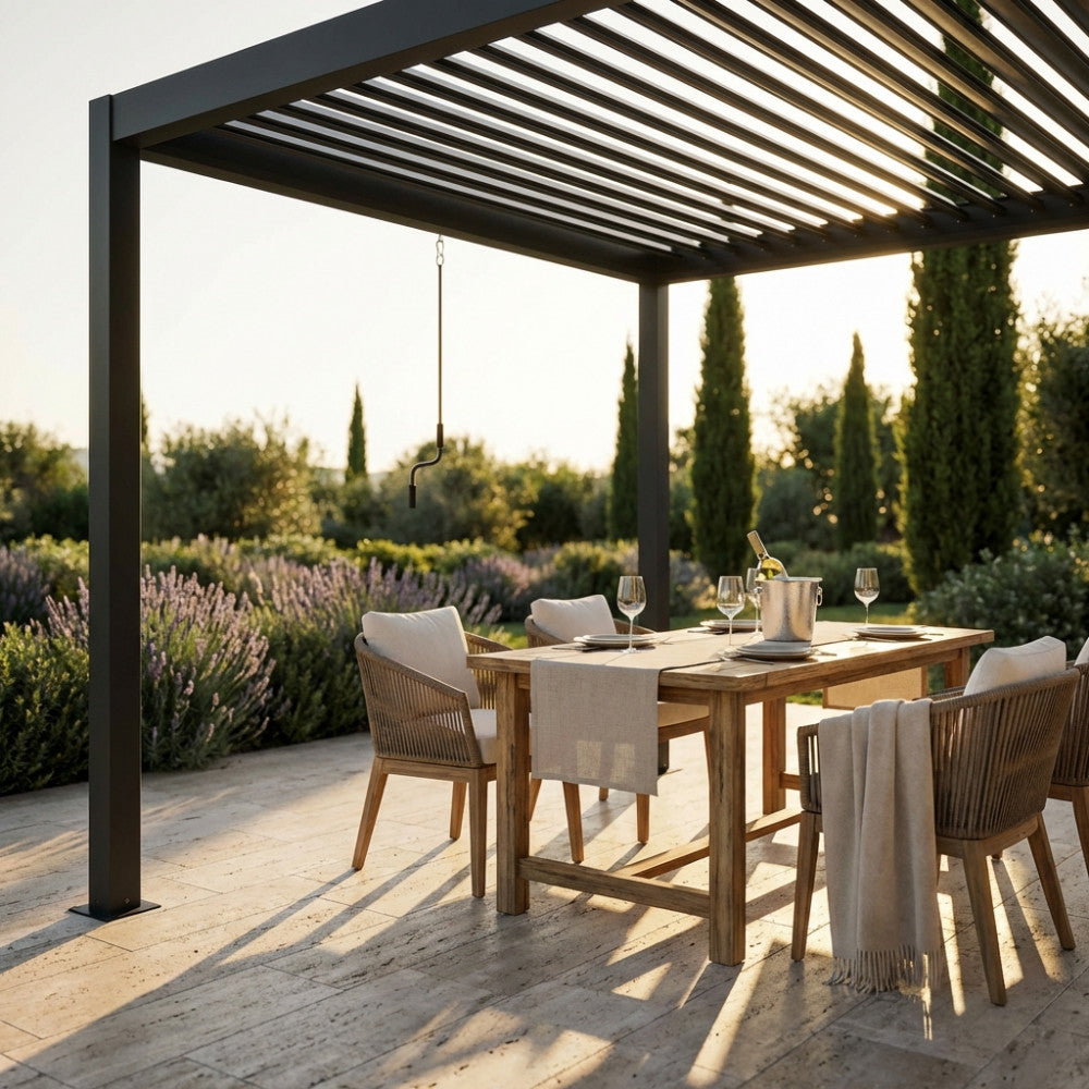 Dettaglio della pergola bioclimatica moderna al tramonto, con tavolo apparecchiato e vista sul giardino mediterraneo.