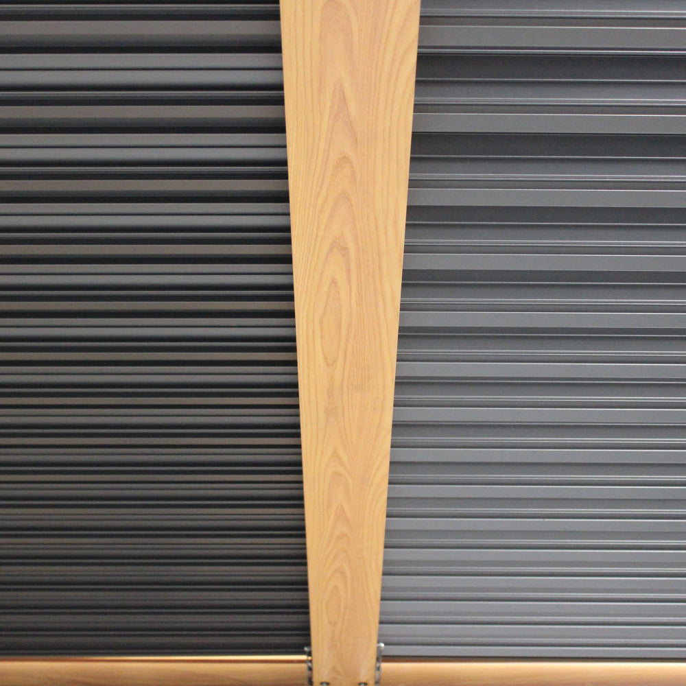 Particolare del contrasto materico tra le lamelle frangisole in alluminio e il montante verticale finitura legno.