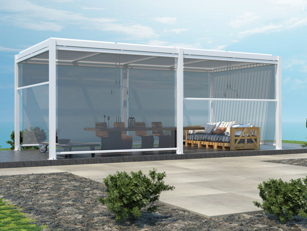 Pergola bioclimatica bianca dotata di tende a caduta laterali semitrasparenti abbassate su una terrazza vista mare.