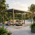 Pergola bioclimatica in alluminio antracite allestita con divano lounge in un giardino di lusso al tramonto.