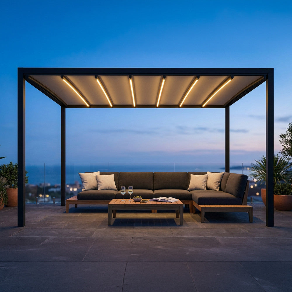 Pergola retrattile motorizzata in alluminio antracite illuminata da luci LED integrate, allestita su una terrazza panoramica al tramonto.