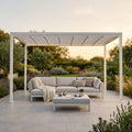 Pergola retrattile motorizzata bianca in alluminio con copertura in PVC estesa e illuminazione LED, posizionata in un giardino lussuoso.