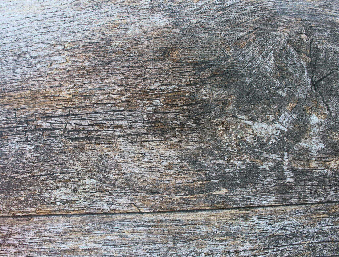 Dettaglio ravvicinato della finitura in acciaio che riproduce fedelmente le venature del legno vissuto.