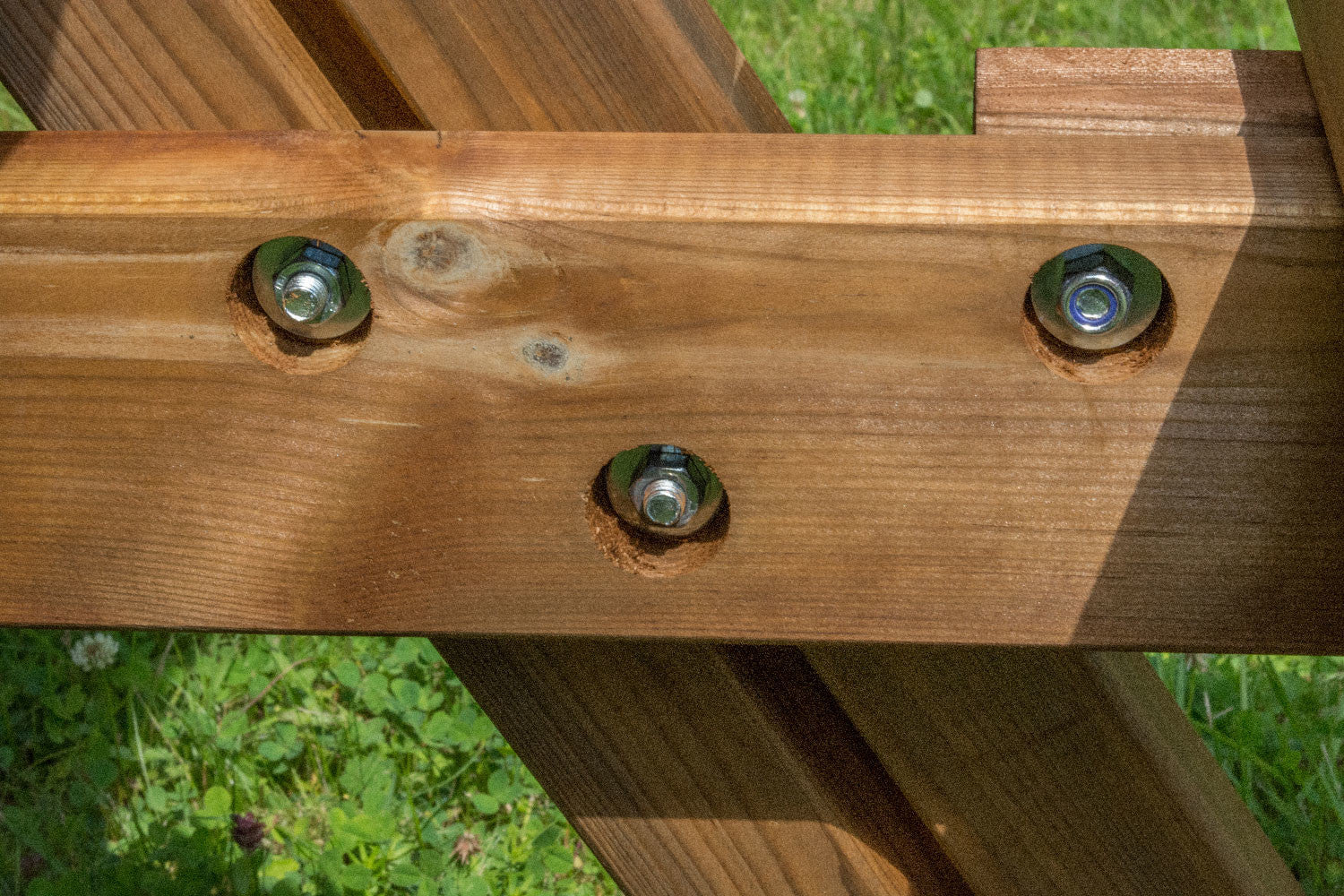 Particolare dei bulloni metallici sul tavolo in legno Losa Esterni da vivere