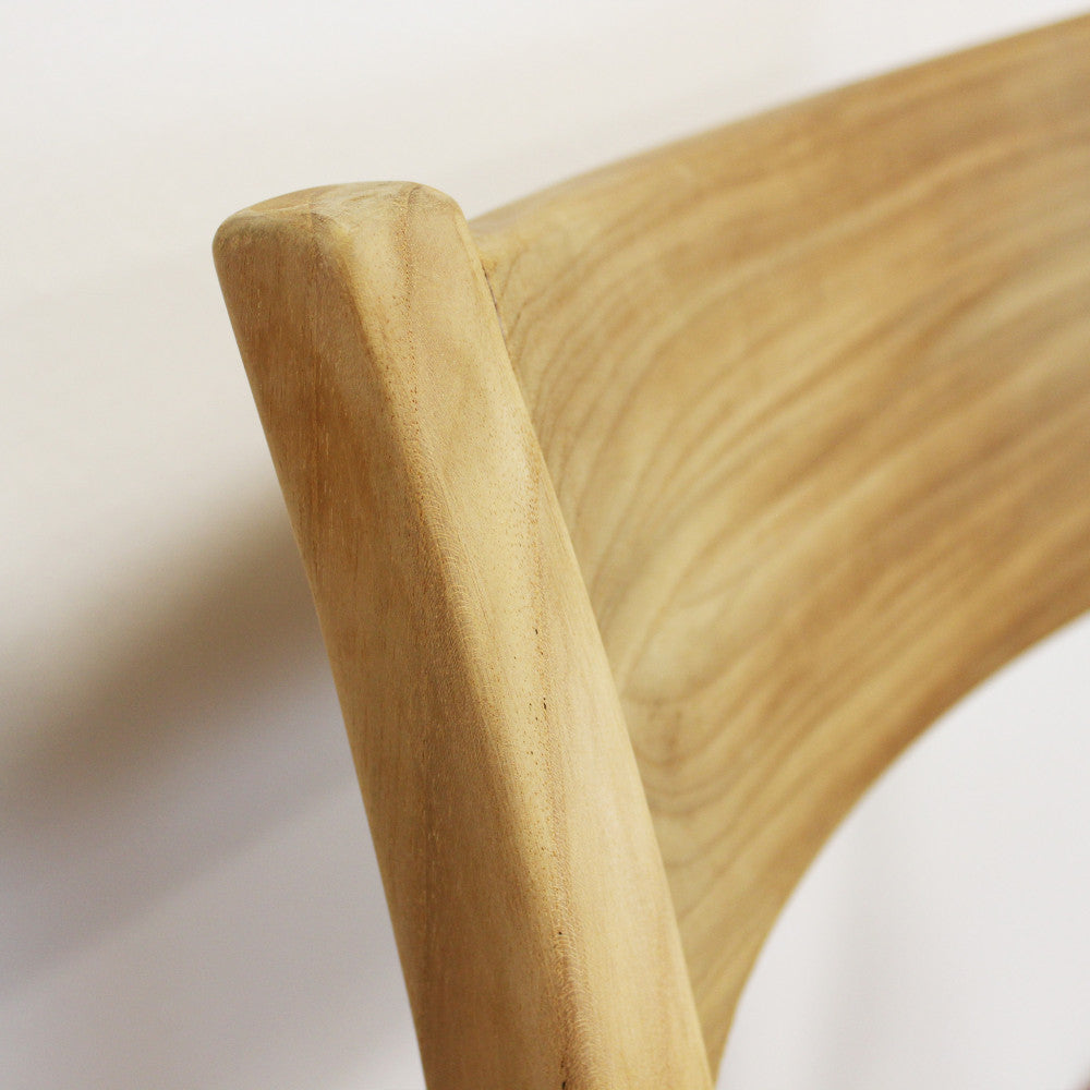 Particolare dello schienale curvo in teak, che mostra le venature naturali e calde del legno.