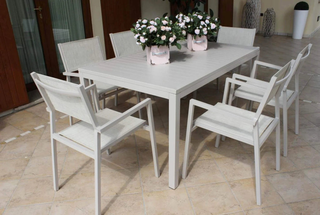 Poltrona Avana Tortora impilabile con struttura in alluminio e seduta in textilene, resistente per esterni, abbinata in veranda con tavolo rettangoalre