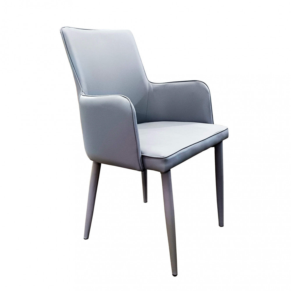 Poltrona Camille Grigio in ecopelle imbottita, inserita in un contesto di salotto moderno.