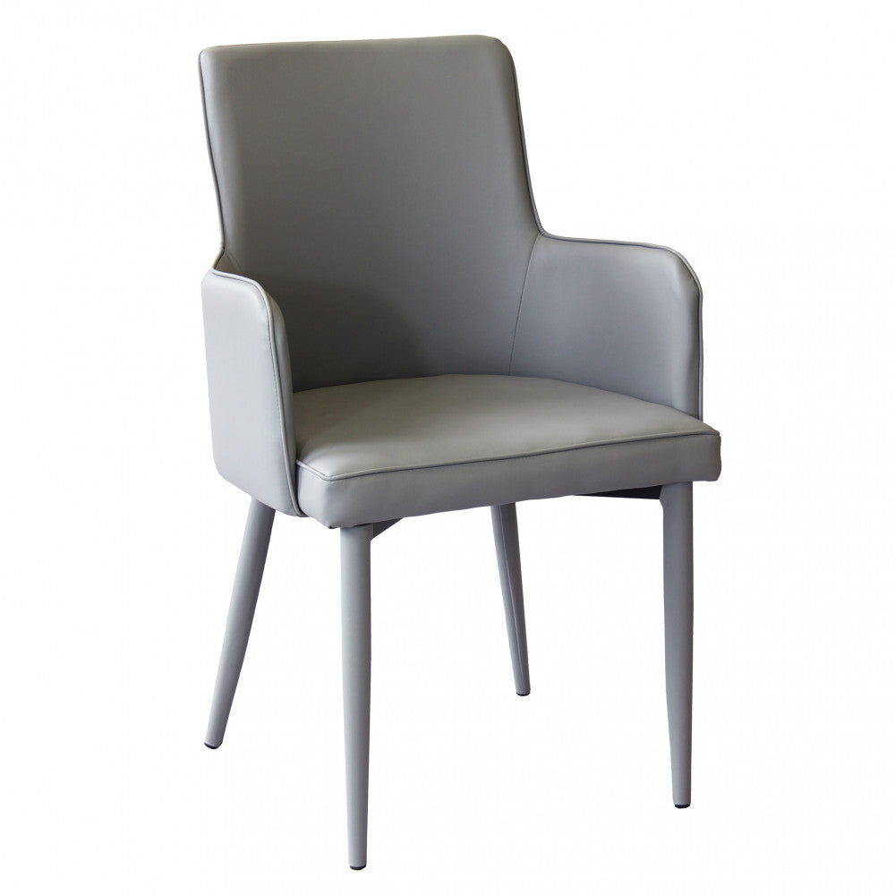 Poltrona Camille Grigio in ecopelle imbottita, inserita in un contesto di salotto moderno.