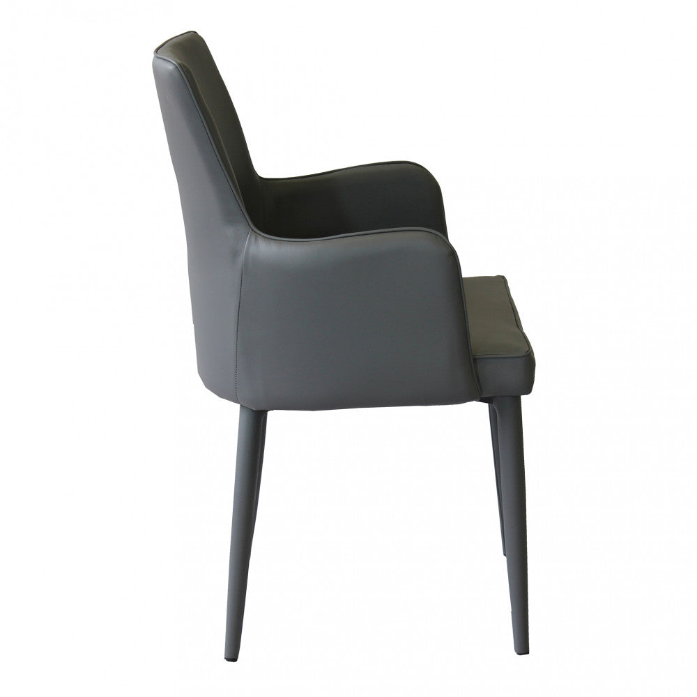 Poltrona Camille Grigio Scuro in ecopelle imbottita, inserita in un contesto di salotto moderno Panoramica Laterale