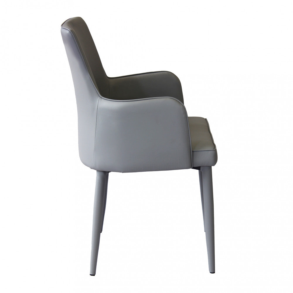 Poltrona Camille Grigio Scuro in ecopelle imbottita, inserita in un contesto di salotto moderno panoramica sinistra