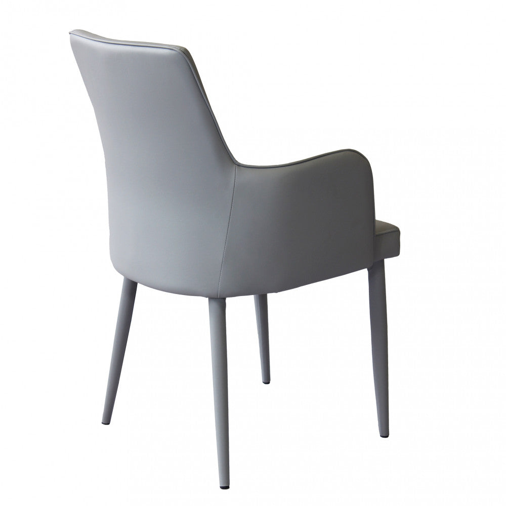 Poltrona Camille Grigio in ecopelle imbottita, inserita in un contesto di salotto moderno vista dal retro sinistro