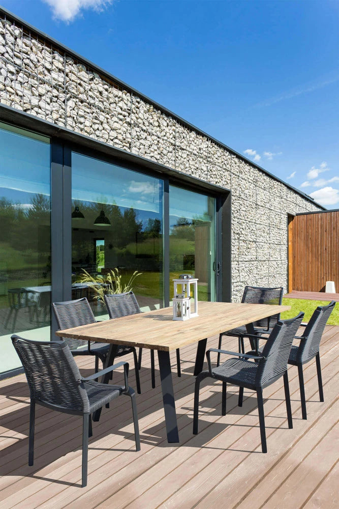 Poltrona Catalina antracite da giardino con design avvolgente e seduta in textilene, ambientazione esterna con tavolo da giardino