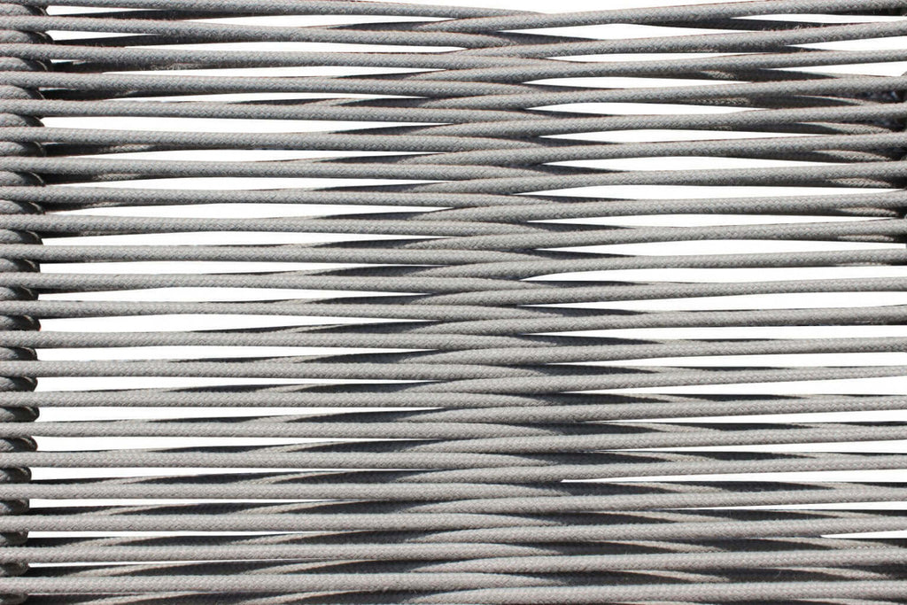 Macro fotografia della texture in corda grigia, che rivela la precisione artigianale e la tensione del materiale della seduta.