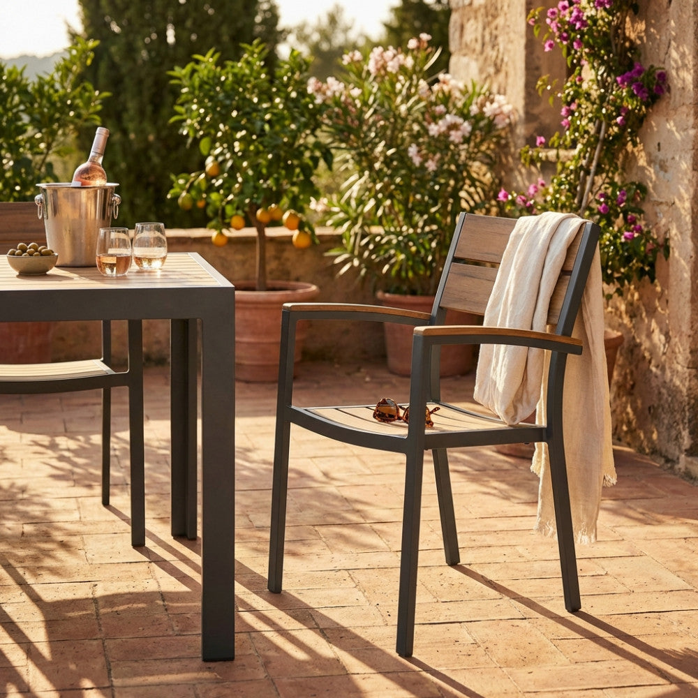 Poltrona CAYMAN in alluminio e polywood taupe ambientata in un patio rustico con tavolo coordinato.