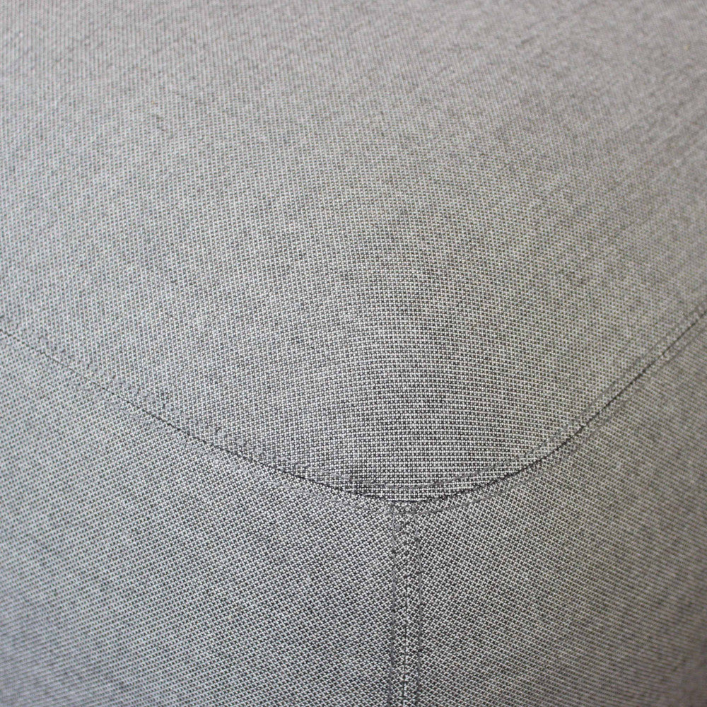 Vista dettagliata del rivestimento in tessuto grigio di alta qualità, che mostra le cuciture sottili e la trama tattile del tessuto.