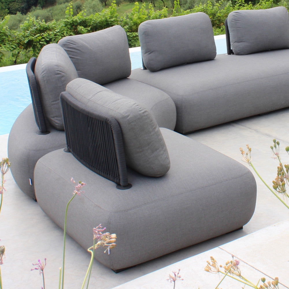 Primo piano della configurazione del divano modulare da esterno accanto a una piscina, che evidenzia la perfetta integrazione delle poltrone grigie.