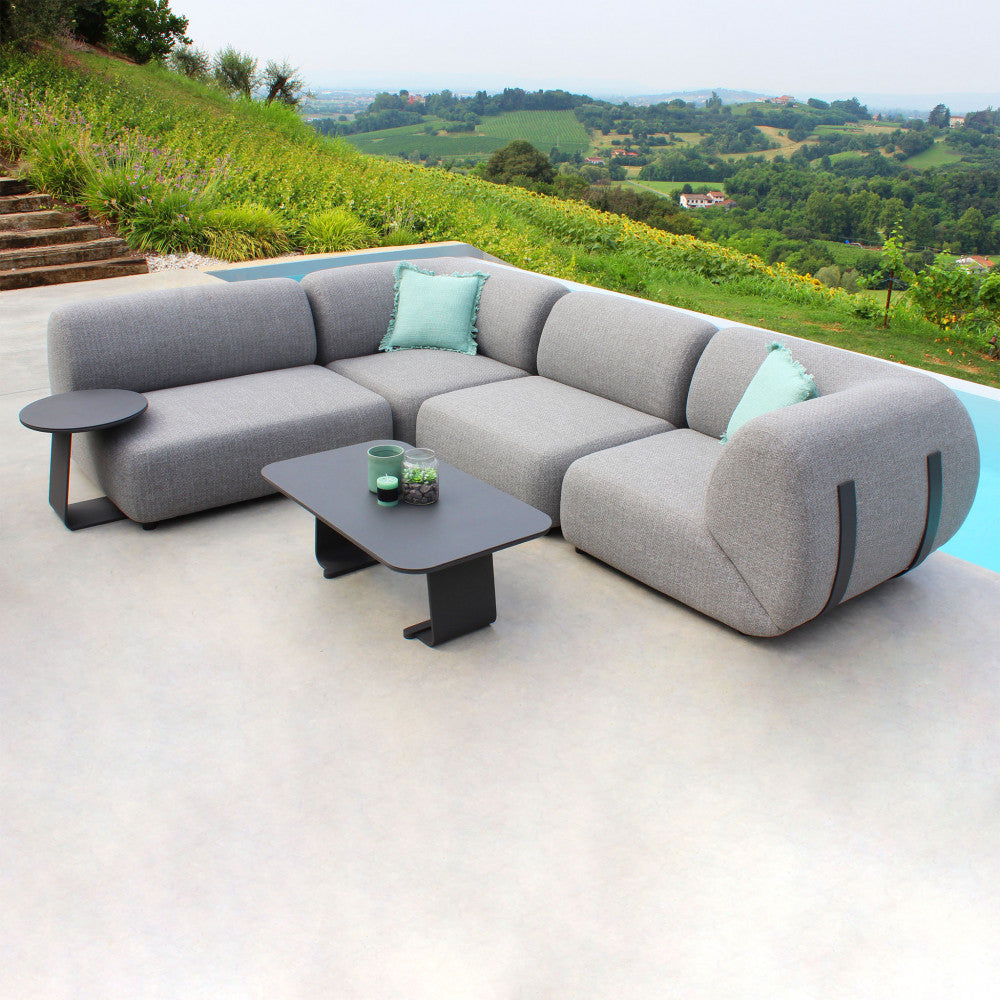 Configurazione lounge completa con moduli Vancouver grigi a bordo piscina, arricchita da cuscini decorativi.
