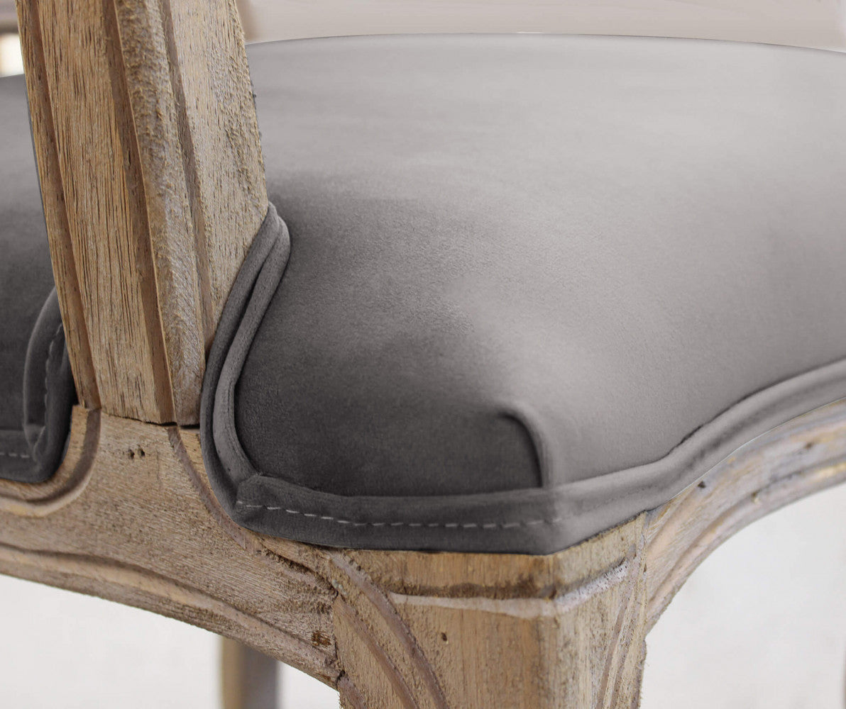 Dettaglio ravvicinato della seduta in velluto taupe della poltrona Charlene, che mostra le cuciture sartoriali e la finitura del legno.