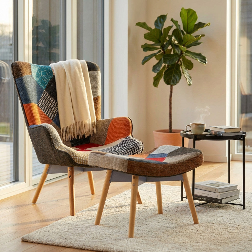 Vista frontale angolata della poltrona Versailles patchwork con poggiapiedi in un living elegante, affiancata da una pianta d'appartamento e un tavolino nero.