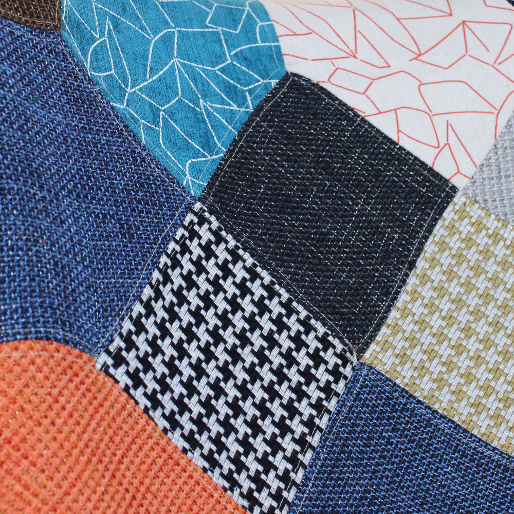 Dettaglio ravvicinato del tessuto patchwork della poltrona Versailles, che mostra la trama tattile e i contrasti cromatici dei vari riquadri.