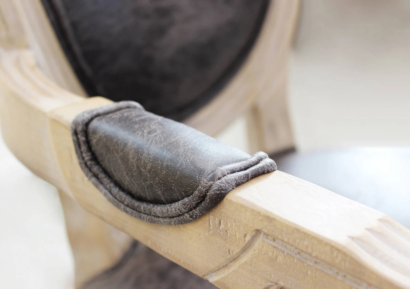 Poltrona Constance imbottita in ecopelle nera, con braccioli e struttura in legno, ideale per ufficio o soggiorno particolare braccioli