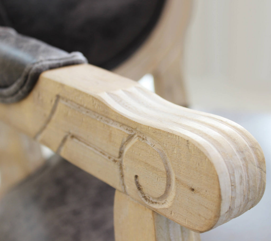 Dettaglio ravvicinato del legno intagliato sul bracciolo della poltrona Constance.