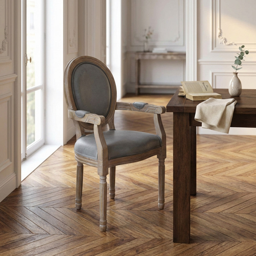 Vista frontale angolata della poltrona in velluto grigio in un salotto luminoso con pavimenti in parquet.