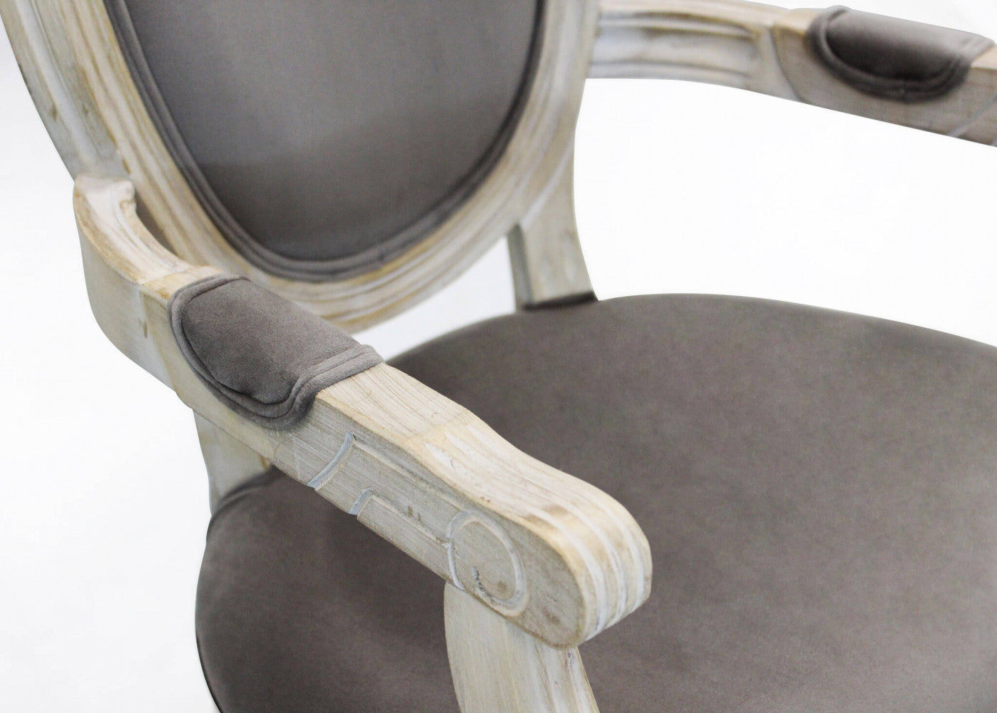 Primo piano del bracciolo imbottito della Poltrona Constance, con focus sulle venature del legno sbiancato e le linee curve del design.