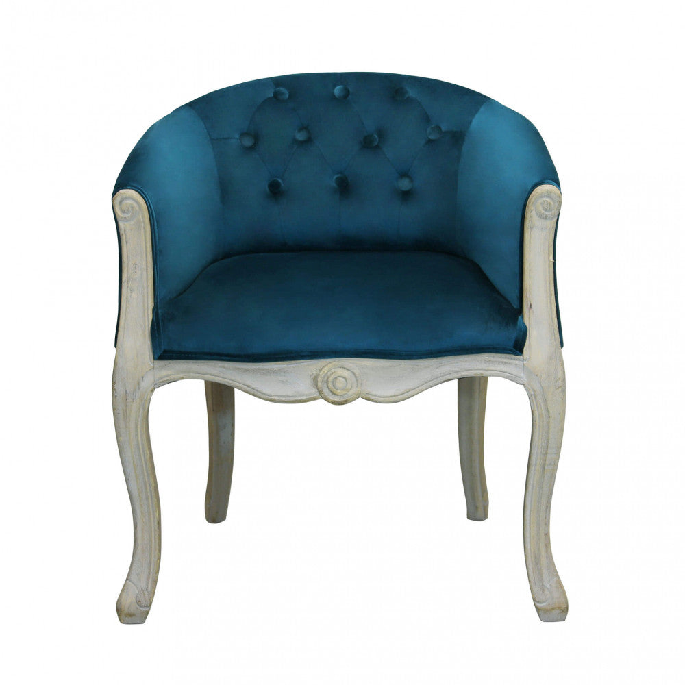 Vista frontale della poltrona Coreen, che evidenzia lo schienale capitonné in velluto blu.