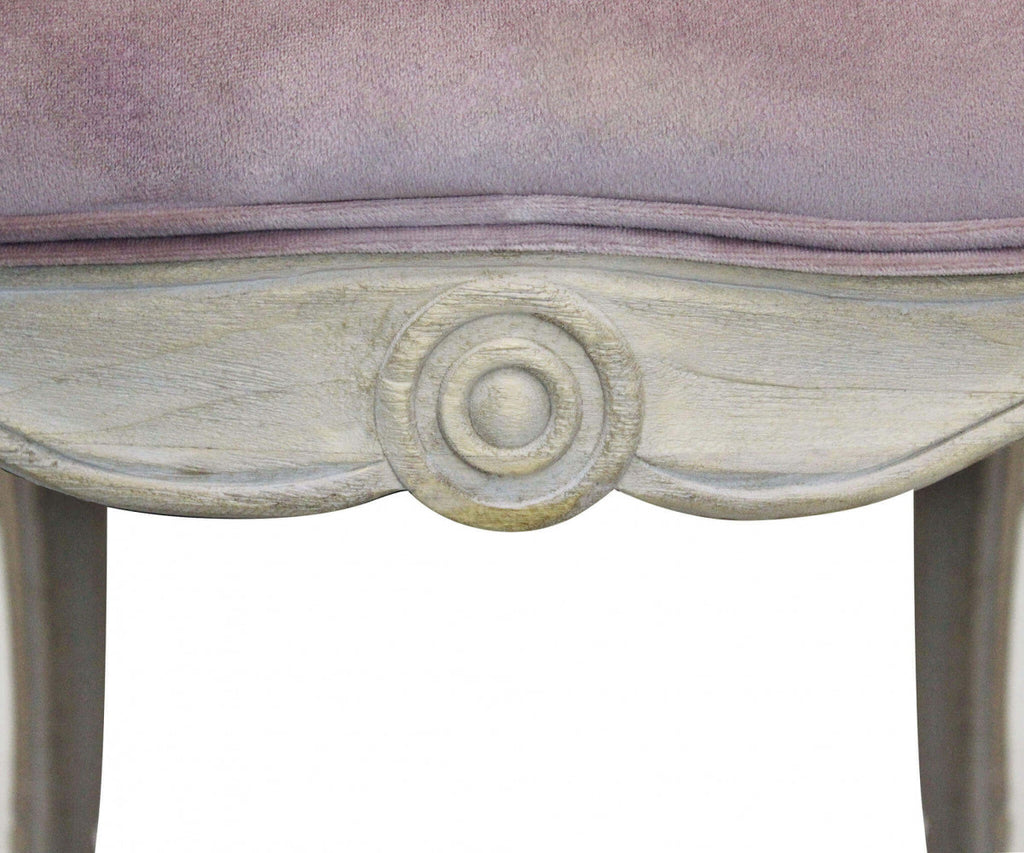 Dettaglio ravvicinato della cornice in legno intagliato con motivo a rosone della poltrona Coreen.