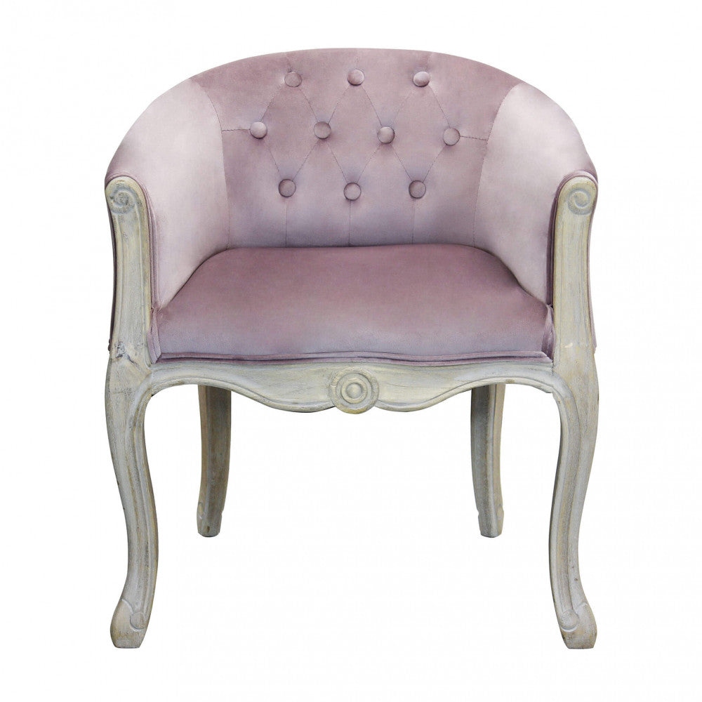 Vista frontale della poltrona Coreen in velluto rosa, che mostra la simmetria del design e le gambe sinuose.