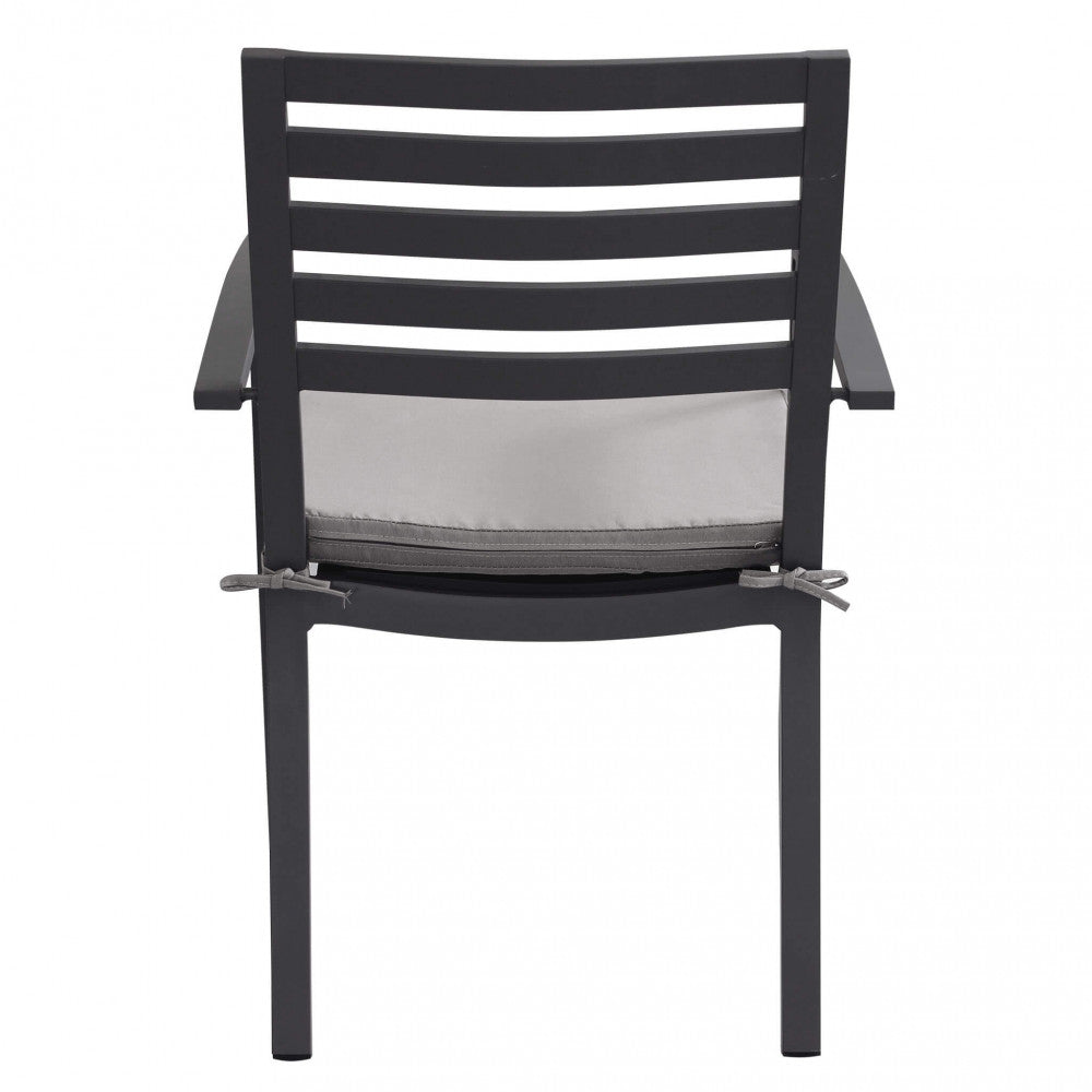 Poltrona da giardino Formentera in alluminio colore antracite con cuscino taupe, posizionata su una terrazza.