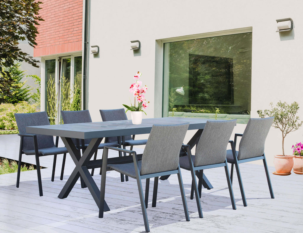 Allestimento primaverile con sedie Djerba impilabili attorno a un tavolo da pranzo su una terrazza moderna.