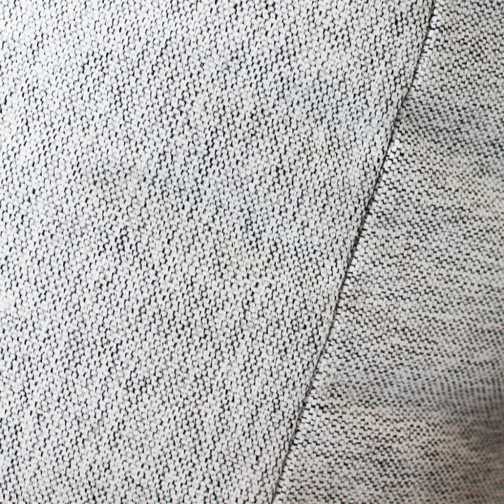 Texture del tessuto bianco grigio chiaro del cuscino, che rivela una trama robusta e raffinata.