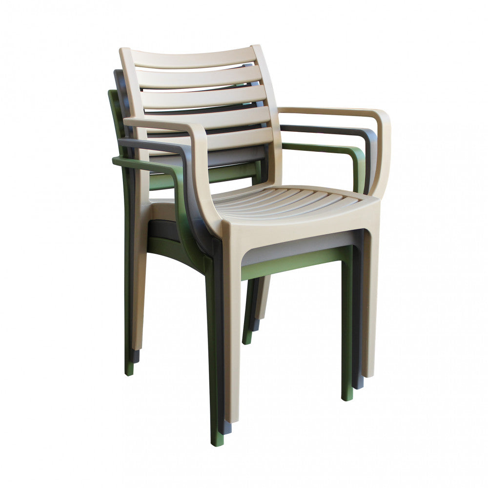 Poltrona Eveline verde scuro in un ambiente esterno elegante e naturale.